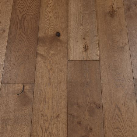 A close-up of coffee-colored wood plank flooring, exhibiting rich, dark brown hues with a smooth, matte finish. The natural wood grain is visible, giving the floor a warm and inviting appearance.
