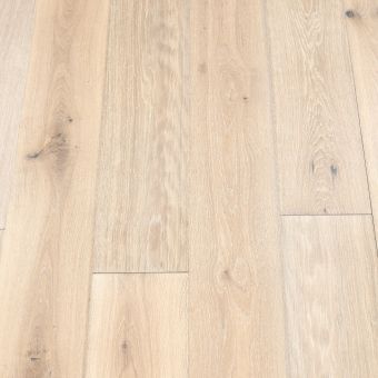 A photograph of plank wood flooring with an ivory-white finish. The planks feature a clean and bright look with natural wood grains, ideal for creating a fresh and open space.