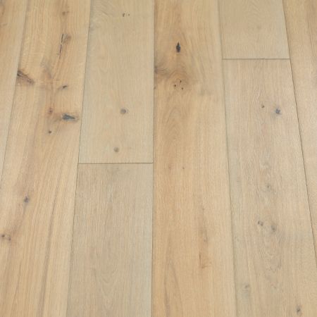 An image featuring plank-style wood flooring with a light pebble-grey finish. The planks have a soft, neutral hue that enhances the natural wood texture, creating a modern and minimalist aesthetic.