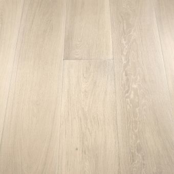 A close-up image of wide wooden planks in a light ivory tone. The smooth surface and soft, pale colour give the floor an airy and spacious feel. The light ivory shade highlights the natural grain of the wood, providing a modern and minimalist aesthetic.