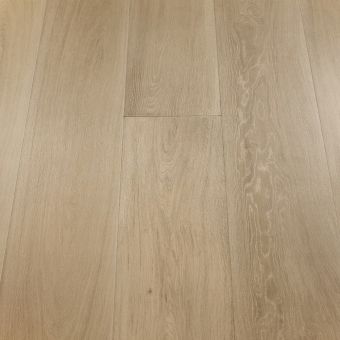 A wide plank wood floor in a taupe finish, displaying soft, warm grey-brown hues. The wide boards emphasize the gentle grain patterns, creating a sophisticated and muted look, ideal for modern, understated interiors.